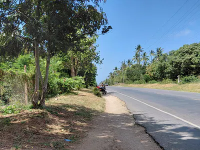 Tarmac road running past a one-acre plot on the Gede–Watamu road